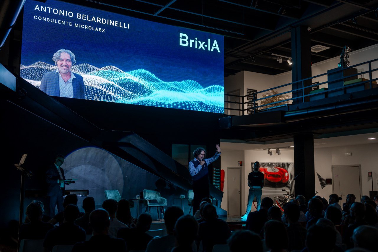 Antonio Belardinelli, consulente di MicrolabX, sul palco di Brix-IA Imprese con la sua immagine proiettata sullo schermo